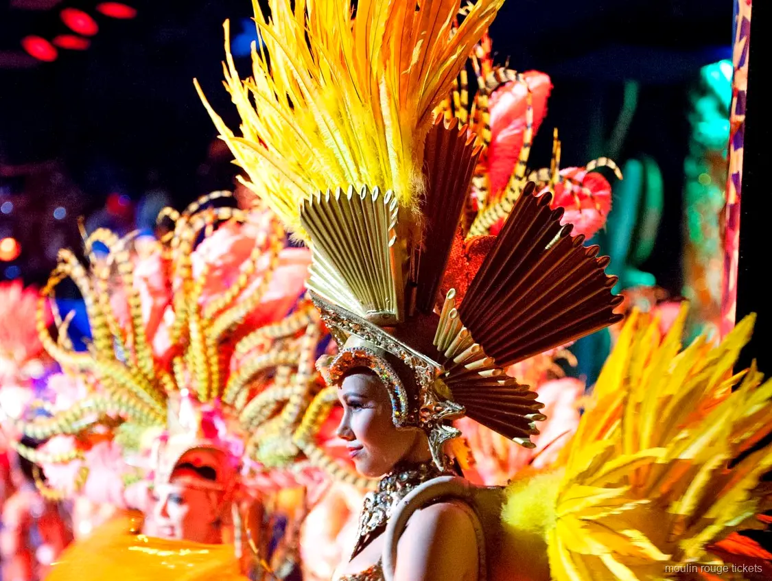 Entrades Moulin Rouge: ballarina amb tocat de plomes daurades i corona en ventall a l'escenari