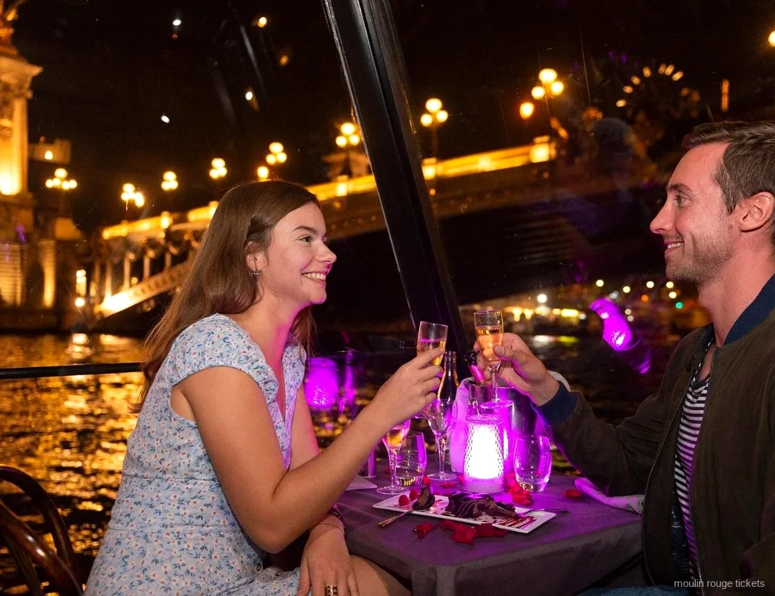 Par skåler i champagne på en middagssejltur på Seinen om aftenen, før showet med Moulin Rouge billetter