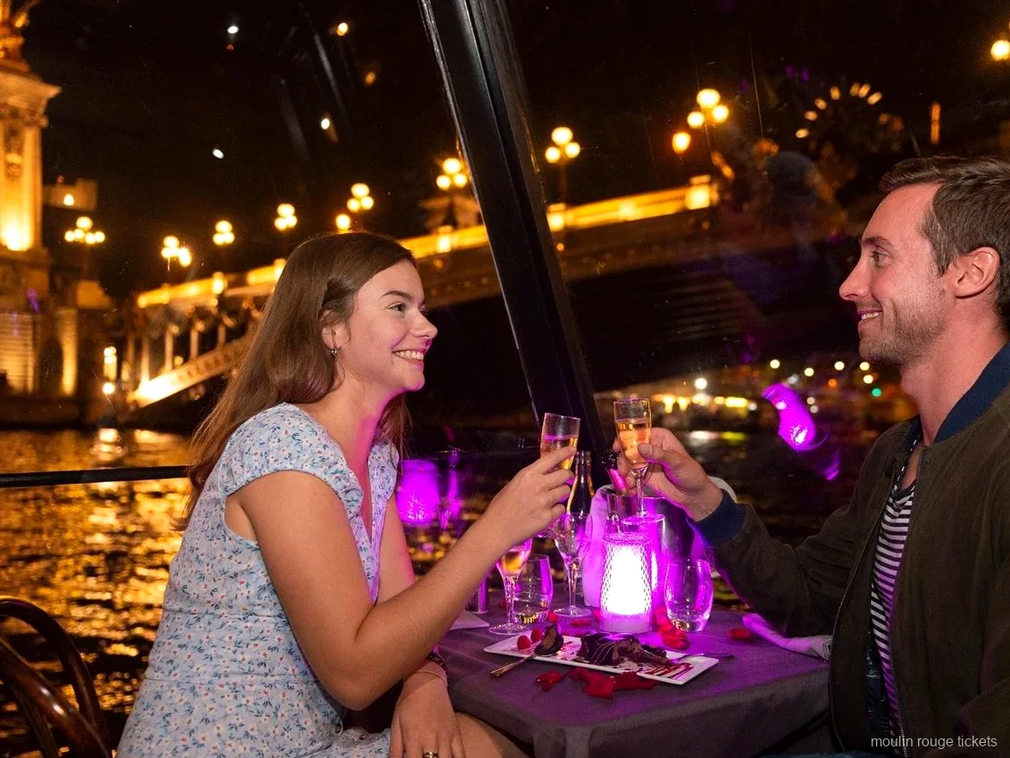 Par skålar i champagne under en kvällsmiddag på Seine, före showen med Moulin Rouge-biljetter i Paris