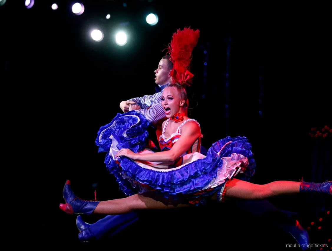 Plateia diante da fila de French Cancan sob o letreiro Moulin iluminado, jantar e show Moulin Rouge