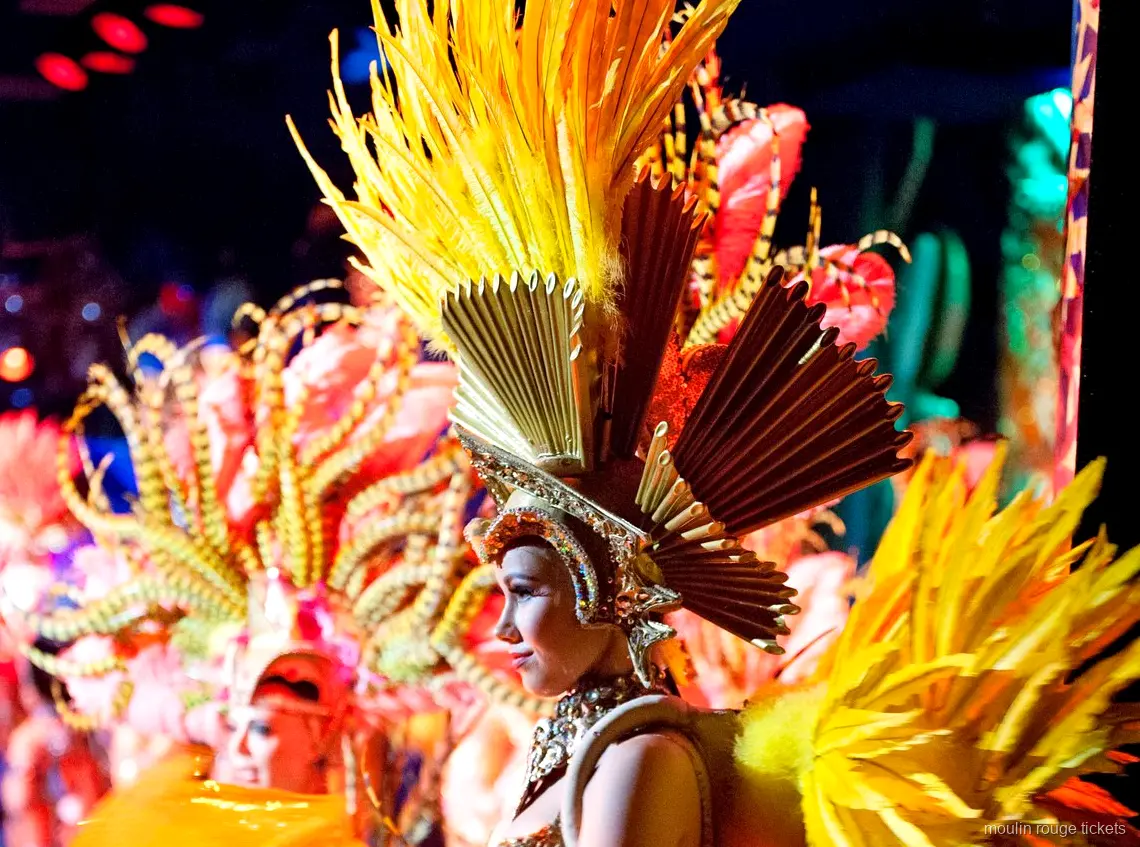 Bilety Moulin Rouge: tancerka w złotym pióropuszu z koroną w kształcie wachlarza na scenie