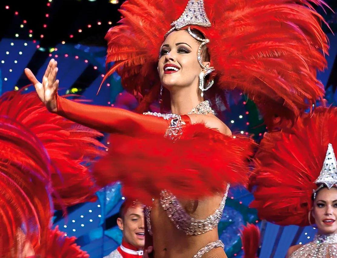 Moulin Rouge biljetter: dansare med röd fjäderhuvudbonad och paljetter under scenljusen