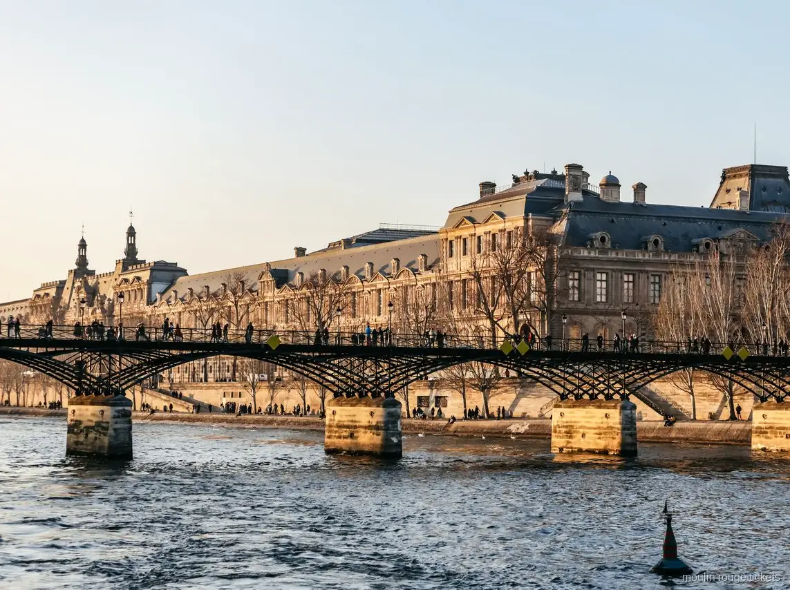 Pont des Arts and the Louvre seen from the Seine at sunset, cruise paired with Moulin Rouge tickets