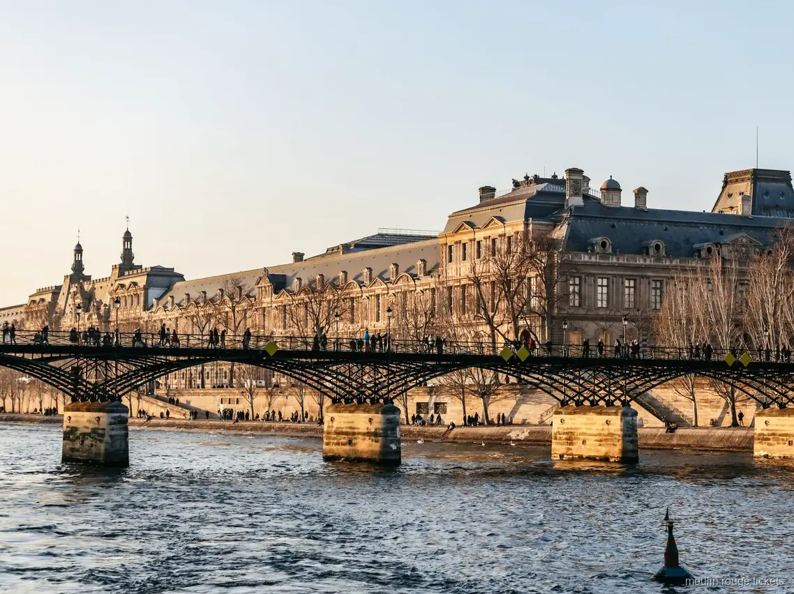 Pont des Arts en het Louvre vanaf de Seine bij zonsondergang, rondvaart met Moulin Rouge tickets