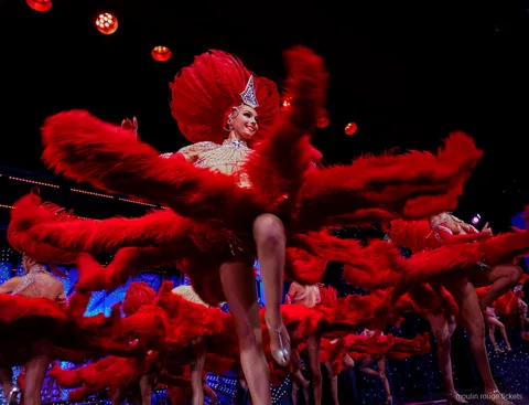 Ballarines fent girar grans ventalls de plomes vermelles, entrades de sopar espectacle Moulin Rouge