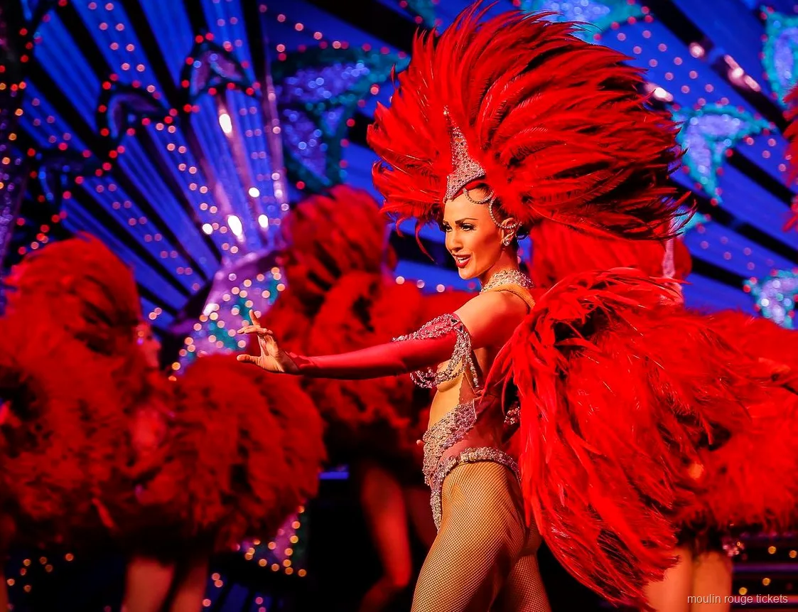 Danseuse avec un grand éventail de plumes rouges devant un décor bleu illuminé, billets Moulin Rouge