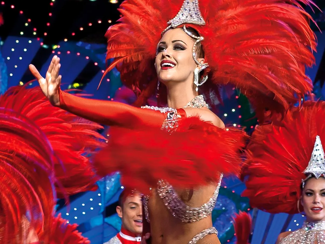 Bilety Moulin Rouge: tancerka w czerwonym pióropuszu i cekinach w świetle sceny