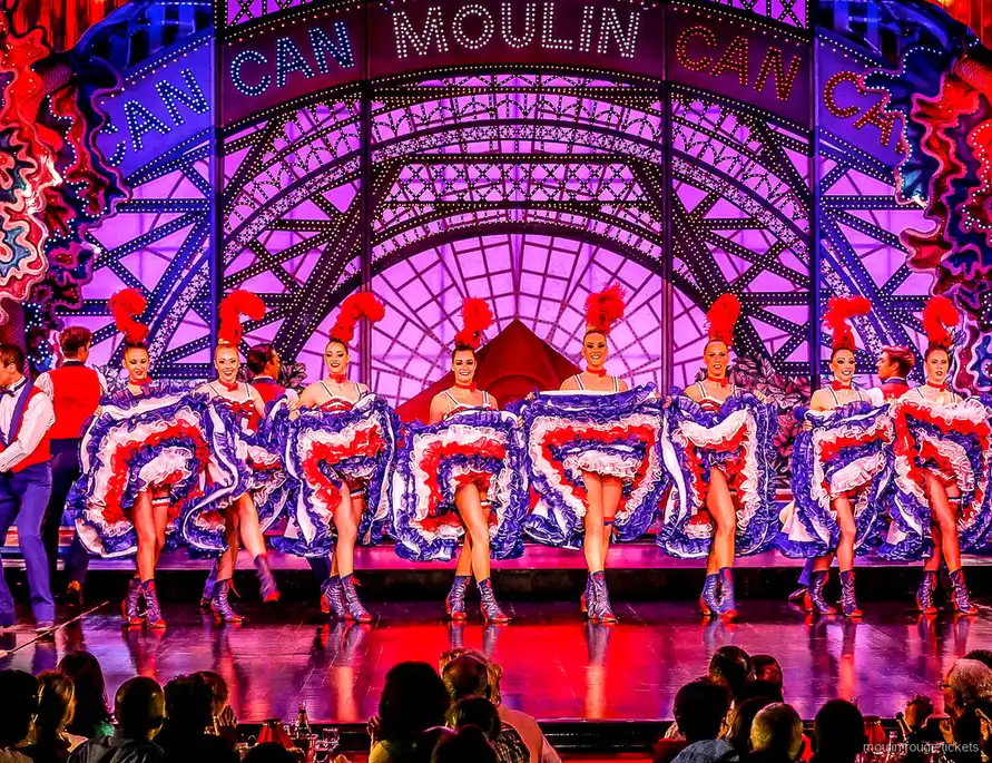 Rząd tancerek French Cancan w trójkolorowych spódnicach pod neonem Moulin, bilety Moulin Rouge